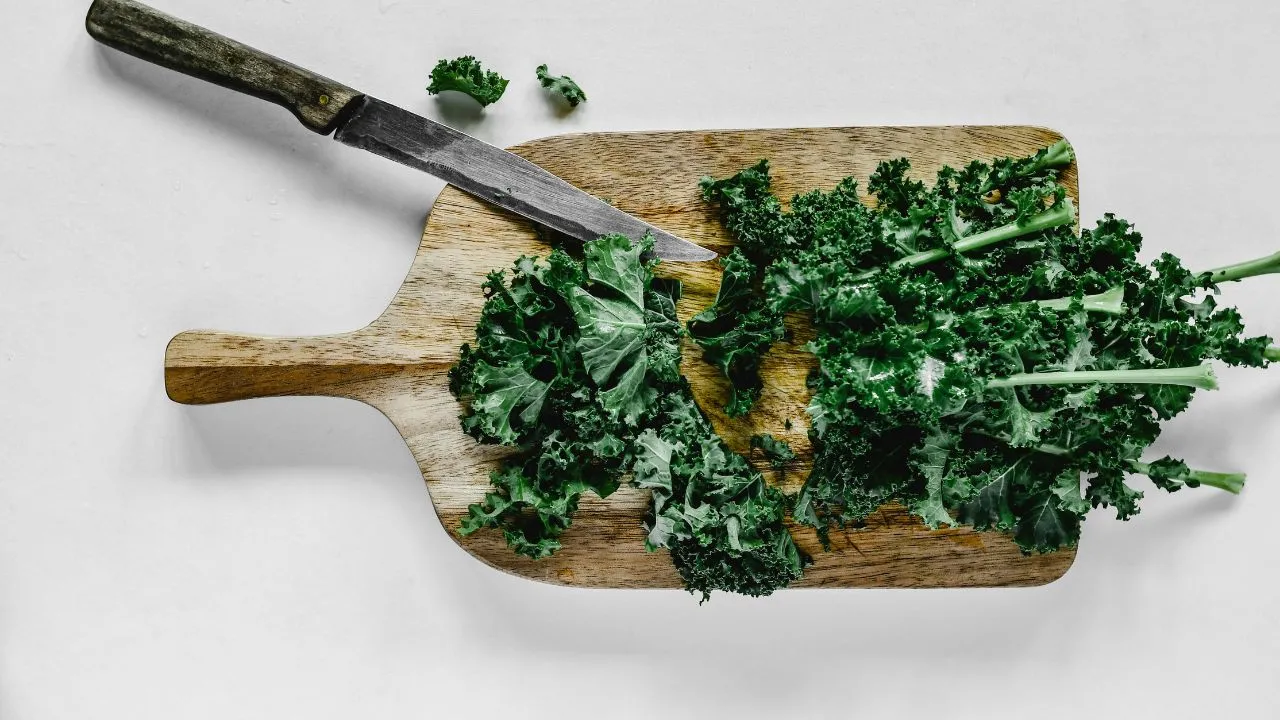 close up shot of chopped kale on a wooden chopping board